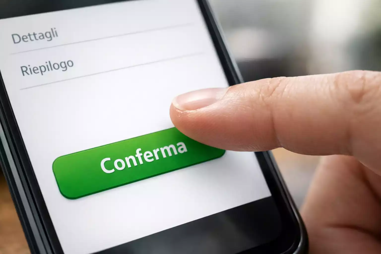 Mano che preme pulsante su schermo smartphone